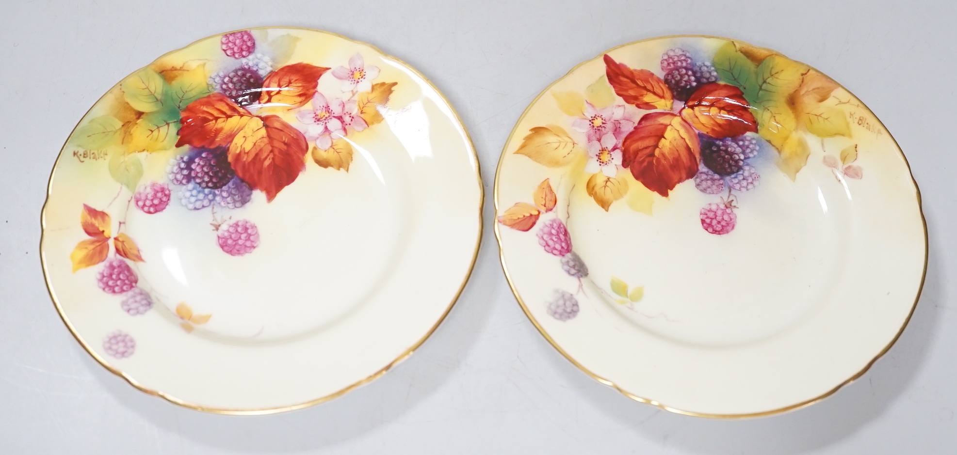 A pair of Royal Worcester lobed tea plates painted with autumnal leaves and berries by Kitty Blake, signed date mark 1935